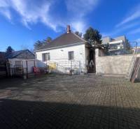 Dvorní exteriér s betonovou dlažbou a rodinným domem ve městě Senica, představený jako gastro prostory.