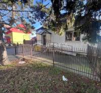 Starší dům obklopený plotem a stromy blízko gastro prostorů v Senici.