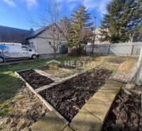 Zahrada u domu v Gastroprostorech v Senici s volnými záhony a dodávkou.