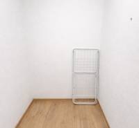 Bílá místnost ve 2-pokojovém bytě s podlahou s dřevěným dekorem a sušákem.