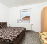 Pokoj v hotelu nebo penzionu s jedinečným vzorem postele a nástěnným obrazem.