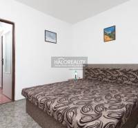 Ložnice s manželskou postelí, bílými stěnami a obrazy v hotelu a penzionech.