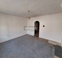 Interiér místnosti s bílými stěnami, koberec a lustr, Pozemky - bydlení.