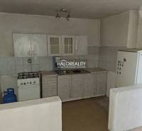 Kuchyňská linka s plynovým sporákem a lednicí v interiéru. Pozemky - bydlení.