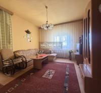 Obývací pokoj v rodinném domě s pohodlnou sedačkou a podlahou s dřevěným dekorem.