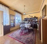 Jídelna v rodinném domě s podlahou s dřevěným dekorem, zdobený koberec a stůl.