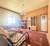 Obývací pokoj v rodinném domě se světlem z okna, dřevěný dekor stěn a nábytek.