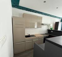 Kuchyně s vestavěnými skříněmi a varnou deskou v rodinném domě.