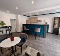 Interiér rodinného domu s barovým pultem, jídelním stolem a pohodlnými židlemi.