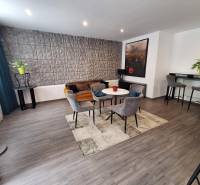 Obývací pokoj s křesly a pohovkou v rodinném domě, dekorativní stěna a barový kout.