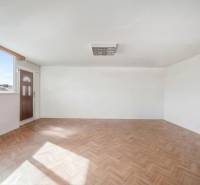 Prostorné obchodní prostory s velkým oknem a podlahou s dřevěným dekorem.