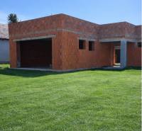 Nedokončený rodinný dům v Dolní Seči s travnatým pozemkem a základy z cihel.