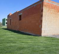 Nedokončená stavba rodinného domu v Dolní Seči obklopená upraveným trávníkem.