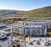 Pohled na obytné budovy na Malokrasňanské ulici v Bratislavě - Rači obklopené zelení.