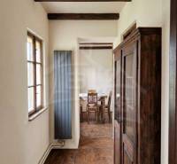 Dřevěné trámy, podlaha s dřevěným dekorem a starožitná skříň v rodinném domě.