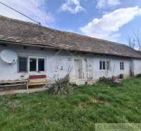 Rodinný dům v Ozdíně s bílou fasádou a satelitní anténou na střeše.