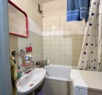 Koupelna v 3-pokojovém bytě s vanou, umyvadlem a pračkou.