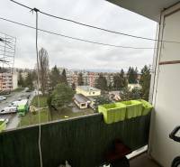 Pohled z balkonu 3pokojového bytu na Říjnové ulici v Prešově, parkoviště a zeleň.