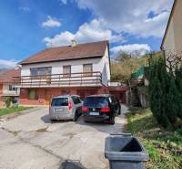 Rodinný dům na ulici Závršky v Myjavě, parkoviště se dvěma auty a zelení.