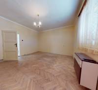 Pokoj v rodinném domě s podlahou s dřevěným dekorem a jednoduchým lustrem.