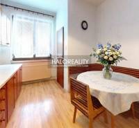 Kuchyně v rodinném domě s podlahou s dřevěným dekorem a květinovou výzdobou.