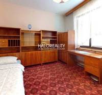 Pokoj s kobercovou podlahou, dřevěným nábytkem v rodinném domě.