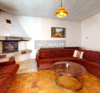 Obývací pokoj s krbem a pohovkou v rodinném domě, s podlahou s dřevěným dekorem.