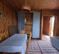 Dřevěný interiér s jídelním stolem, pohovkou a závěsy, Pozemky - bydlení.