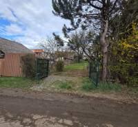 Brána obklopená zelení a plotem na Pozemky - bydlení v Bohdanovicích.