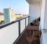 Balkon 3-pokojového bytu na Púpavové ulici v Bratislavě - Karlova Ves s dřevěným dekorem podlahy.