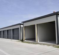 Garáže v Michale na Ostrově se šedou fasádou a otevřenými vraty.