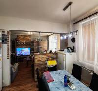 Jídelna ve 4-pokojovém bytě s podlahou s dřevěným dekorem a televizí.