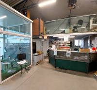 Obchodní prostory se skleněnou stěnou a pracovním prostorem, podlaha s dřevěným dekorem.