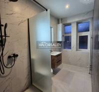 Koupelna v 2-pokojovém bytě s vanou a sprchou, obklady s imitací mramoru.