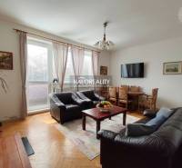 Obývací pokoj s koženými sedačkami a televizorem, s podlahou s dřevěným dekorem.