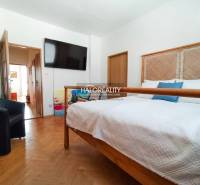 Koupelna v 3-pokojovém bytě s pračkou a vanou za závěsem.