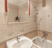 Koupelna s vanou, umyvadlem a zrcadlem ve 3-pokojovém bytě.