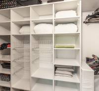 Úložný prostor s policemi a věšáky ve 3-pokojovém bytě s podlahou s dřevěným dekorem.