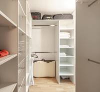 Šatník s regály a podlahou s dřevěným dekorem ve 3-pokojovém bytě.