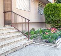 Vchod do 3-pokojového bytu na Nábrežní ulici v Nových Zámcích s květinovou zahrádkou.