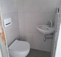 Malá koupelna v rodinném domě s pračkou a umyvadlem.