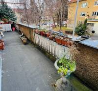 Balkón s květináči a výhledem na ulici F. Madvu v Prievidzi nabízí klidné prostředí.
