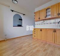 Kuchyně ve 3-pokojovém bytě s podlahou s dřevěným dekorem a vestavěnými skříňkami.