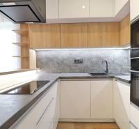 Kuchyně s hladkými liniemi a podlahou s dřevěným dekorem ve 3pokojovém bytě.