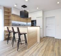 Kuchyně v 3-pokojovém bytě s barovým pultem a podlahou s dřevěným dekorem.