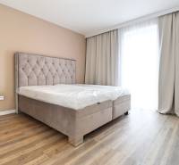 Ložnice s postelí a podlahou s dřevěným dekorem ve 3-pokojovém bytě.