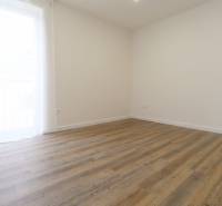 Pokoj v 3-pokojovém bytě s podlahou s dřevěným dekorem a jednoduchým designem.