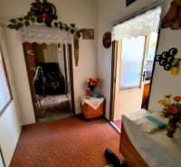 Vstupní chodba ve 3-pokojovém bytě s dekoracemi a květinami na stole.