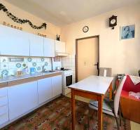 Kuchyně ve 3pokojovém bytě s bílými skříňkami a dekorativními dlaždicemi.