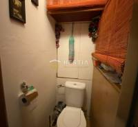 Malá toaleta v 2-pokojovém bytě s dekorativními bambusovými prvky a obrázky na stěně.